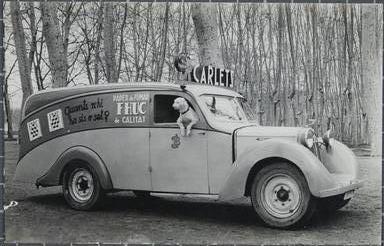Fotografia: Vista lateral d'un vehicle Renault amb publicitat de la fàbrica Paper Carlets.
